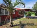 Red house exterior with palm tree and partial carport view at 10 Mccarthy Ave, Frostproof, FL 33843