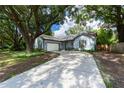 Light blue house with a large tree in the front yard at 5525 Barma St, Orlando, FL 32807