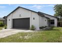 Newly renovated home with white brick exterior and a dark gray garage at 10544 Wyndcliff Dr, Orlando, FL 32817