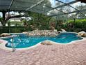 Inviting kidney-shaped pool with a waterfall feature and screened enclosure at 3336 Edgecliffe Dr, Orlando, FL 32806
