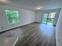 Living room with gray laminate floors and sliding doors to balcony at 1908 Lake Atriums Cir # 20, Orlando, FL 32839