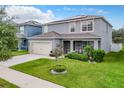 Two-story house with gray siding, solar panels, and a two-car garage at 1526 White Hawk Way, Groveland, FL 34736