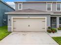 Two-car garage with beige doors and black accents at 1526 White Hawk Way, Groveland, FL 34736
