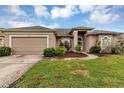 Tan house with two-car garage and manicured landscaping at 13728 Dornoch Dr, Orlando, FL 32828