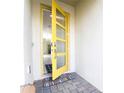 Modern entryway with yellow door and welcome mat at 8930 Cabot Cliffs Dr, Davenport, FL 33896