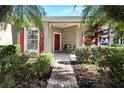 Front porch with red shutters, red door, hanging light fixture and bistro set at 217 Anastasia Dr, Kissimmee, FL 34759