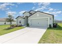 Newly constructed home with a two-car garage and well-manicured lawn at 1333 Brenway Dr, Mascotte, FL 34753