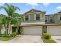 Two-story townhome with light green exterior, two-car garage, and landscaping at 3349 Rodrick Cir, Orlando, FL 32824