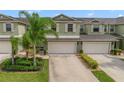 Two-story townhome with light green exterior, two-car garage, and landscaping at 3349 Rodrick Cir, Orlando, FL 32824