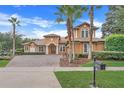 Two-story house with brick driveway and palm trees at 9106 Panzani Pl, Windermere, FL 34786