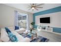 Living room with white sectional sofa, large TV, and blue accent wall at 4804 Memories Ln, Kissimmee, FL 34746