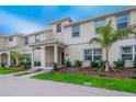Two-story townhome with front porch, landscaping, and palm trees at 4804 Memories Ln, Kissimmee, FL 34746