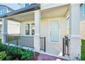Front porch with light blue door and black railing at 11960 Bracco St, Winter Garden, FL 34787
