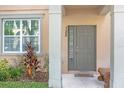 Front entrance with gray door, landscaping, and a bench at 8253 Maritime Flag St # 125, Windermere, FL 34786