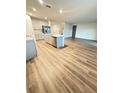 Open concept kitchen and living room with light gray cabinets and wood-look flooring at 420 Quarry Rock Cir, Kissimmee, FL 34758