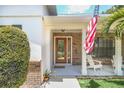 Brick front porch with a wooden door and American flag at 7904 Dunstable Cir, Orlando, FL 32817