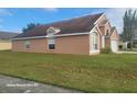 Tan one-story house with a large grassy yard and attached garage at 2108 Shannon Lakes Blvd, Kissimmee, FL 34743