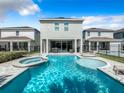 Relaxing pool and spa with lounge chairs, providing a perfect backyard oasis at 7702 Graben St, Kissimmee, FL 34747