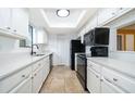 White kitchen with black appliances and quartz countertops at 3936 Magnolia Pointe Ln, Orlando, FL 32810