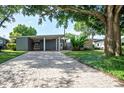 Mid-century modern home with a brick driveway and lush landscaping at 2148 Chippewa Trl, Maitland, FL 32751