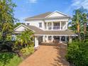 Two-story home with a large porch and brick driveway at 7481 Gathering Loop, Reunion, FL 34747
