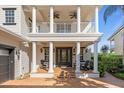 Front porch with columns, rocking chairs, and double door entry at 7481 Gathering Loop, Reunion, FL 34747