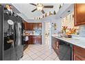 Kitchen with dark wood cabinets, black appliances, and tile floor at 2713 Chatham Cir, Kissimmee, FL 34746