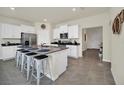 Modern kitchen with white cabinets, granite island and breakfast bar at 7876 Oak Reflection Loop, Davenport, FL 33837