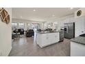 Open kitchen with island, granite countertops, and stainless steel appliances at 7876 Oak Reflection Loop, Davenport, FL 33837
