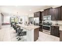 Modern kitchen with granite island, stainless steel appliances, and dark cabinets at 420 Lasso Dr, Kissimmee, FL 34747