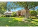 Brick house with a large tree and well-maintained landscaping at 1434 Hidden Meadow Way, Apopka, FL 32712