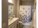 Bathroom with double vanity and floral shower curtain at 17112 Basswood Ln, Clermont, FL 34714