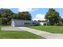 Gray house with a green lawn and long driveway at 2009 Lakeshore Blvd, Saint Cloud, FL 34769