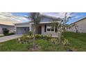 Single-story home with gray siding, landscaping, and a two-car garage at 1007 Theodore St, Davenport, FL 33837