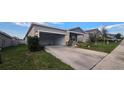 Single-story home with gray siding, landscaping, and a two-car garage at 1007 Theodore St, Davenport, FL 33837