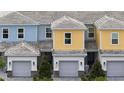 Aerial view of townhomes with gray garages and colorful siding at 7925 Draw St, Reunion, FL 34747