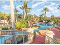 Community pool with water features, a slide, and lush landscaping at 319 Verona Ave, Davenport, FL 33897