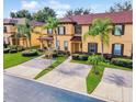 Two-story townhome with brick paver driveway and palm trees at 319 Verona Ave, Davenport, FL 33897