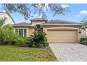 Tan one-story house with two-car garage and landscaped yard at 1381 Hazeldene Mnr, Deland, FL 32724