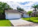 Single-story house with a two-car garage, and lush green lawn at 709 Del Rio Way, Kissimmee, FL 34758