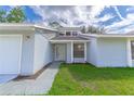 Newly renovated light blue house with a white door and well-maintained lawn at 709 Del Rio Way, Kissimmee, FL 34758