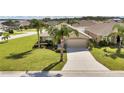 Tan one-story house with palm trees and a two-car garage at 4070 Island Lakes Dr, Winter Haven, FL 33881