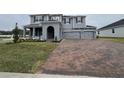 Two-story house with gray siding, three-car garage, and landscaped front yard at 3295 Roseville Dr, Apopka, FL 32712