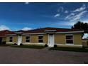 Front view of three-unit building with yellow exterior and tile roofs at 1652 Cumin Dr, Poinciana, FL 34759