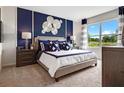 Spacious bedroom with a large bed, dark blue accent wall, and plenty of natural light at 2014 Red Rock Rd, New Smyrna Beach, FL 32168