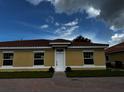 Tan single-story house with a red tile roof and white door at 1648 Cumin Dr, Kissimmee, FL 34759