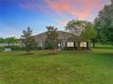 House exterior at sunset, featuring landscaping at 24341 Milford Dr, Eustis, FL 32736