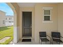 Two chairs on a covered front porch with a dark door at 5116 Killarney Way, Kissimmee, FL 34746
