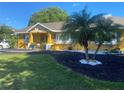 Bright yellow house with landscaping and a palm tree at 8272 Le Mesa St, Orlando, FL 32827