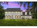 Two-story house with gray siding, wooden shutters, and a manicured lawn at 12200 Treetop Ct, Orlando, FL 32832